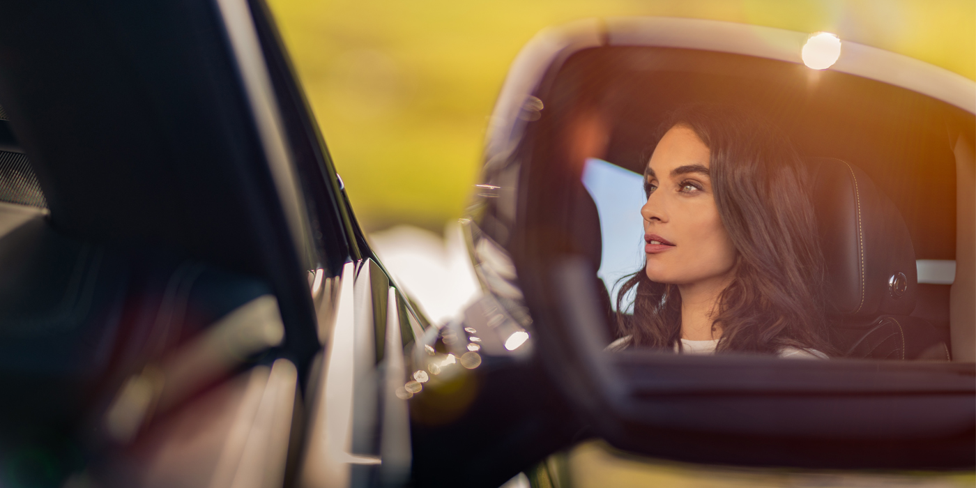Bentley Adelaide profile of dark haired woman's face in mirror of Bentley car in sunlight