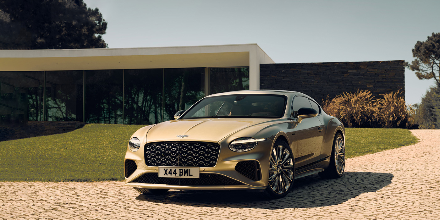 Bentley Adelaide Bentley Continental GT Mulliner coupe front three quarters in Patina paint parked outside a glass fronted building with a grass lawn behind it