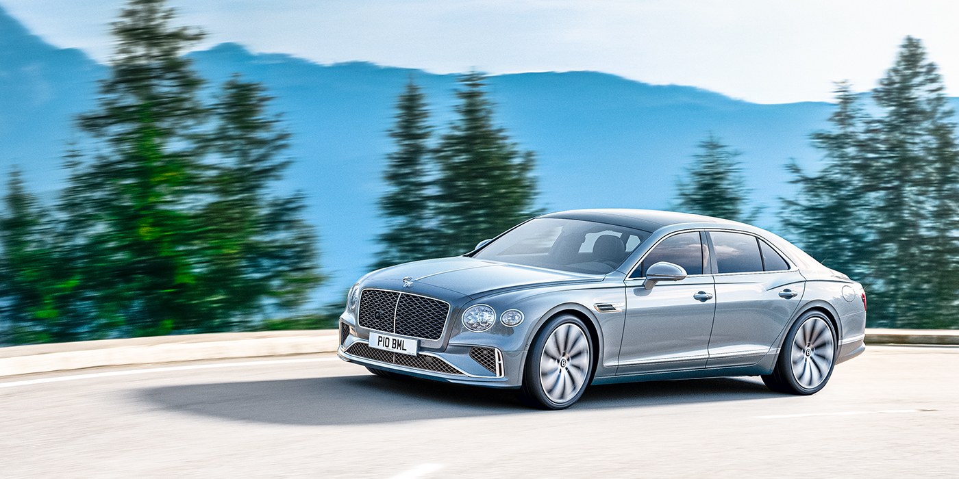 Bentley Adelaide New Bentley Flying Spur sedan side view in Silverlake paint with ten spoke wheels and chrome matrix grille driving dynamically on a mountain road